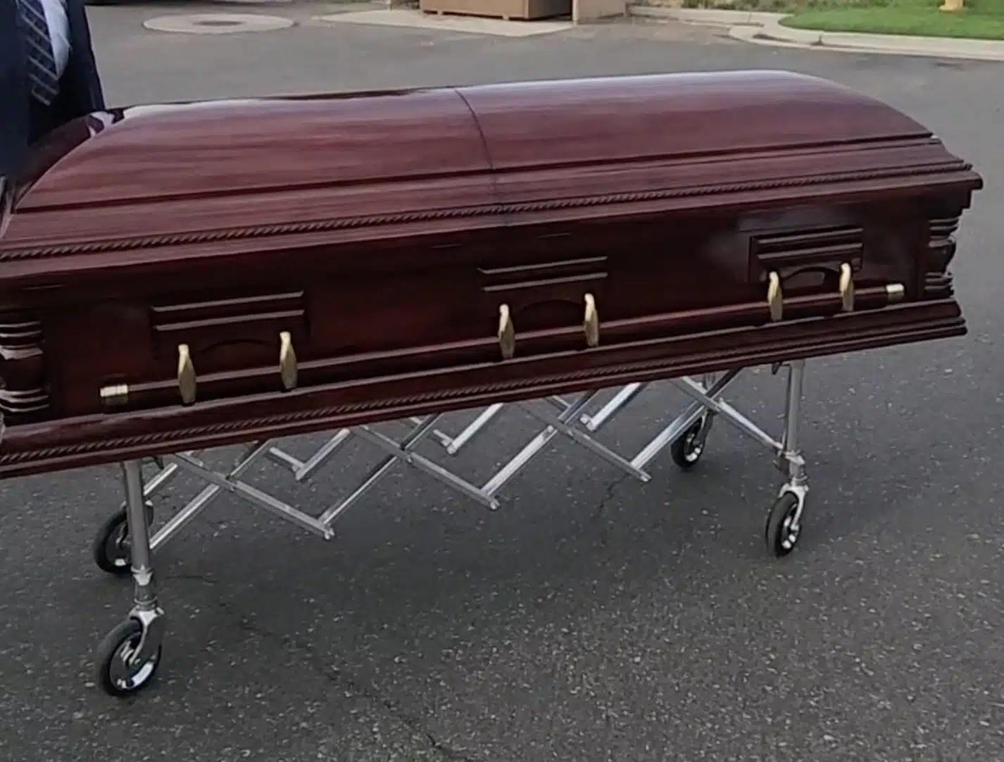 The Wasatch Walnut Wood Casket (Solid Walnut Wood) with brass handles is delivered to the Funeral Home